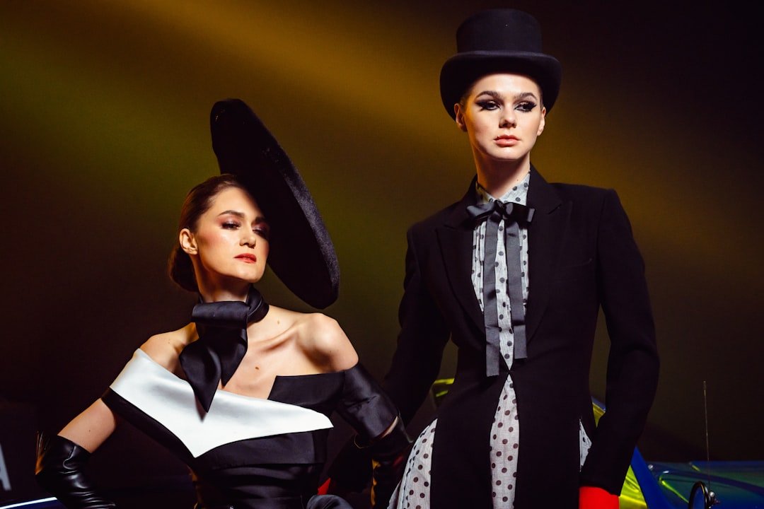 Models walking down a Paris fashion week runway with dramatic lighting and seated audience